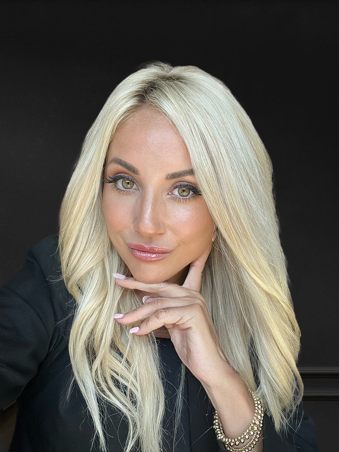 Smiling woman with long blonde hair, professional attire.