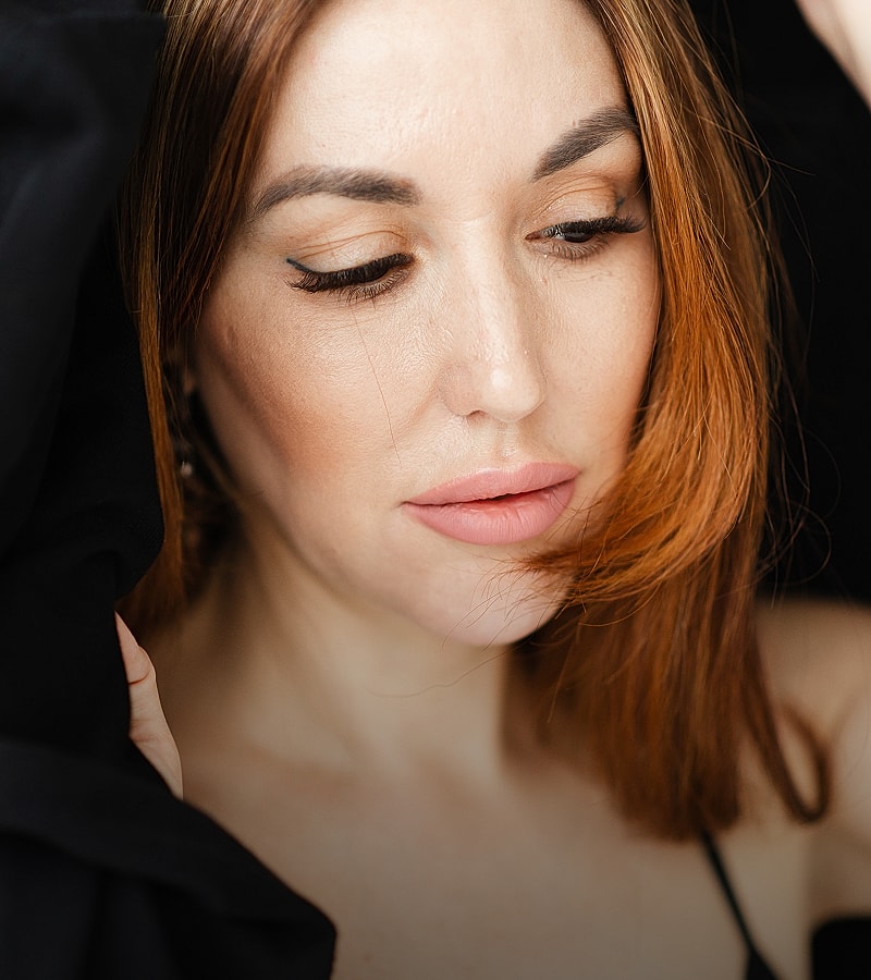 Woman with red hair and soft makeup.