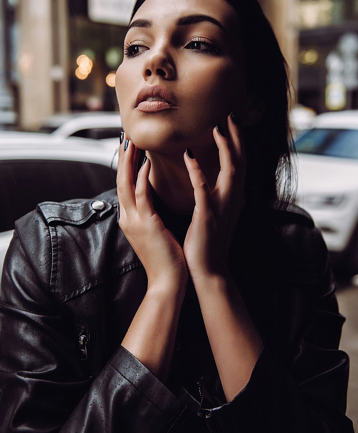 Model posing thoughtfully in urban setting.