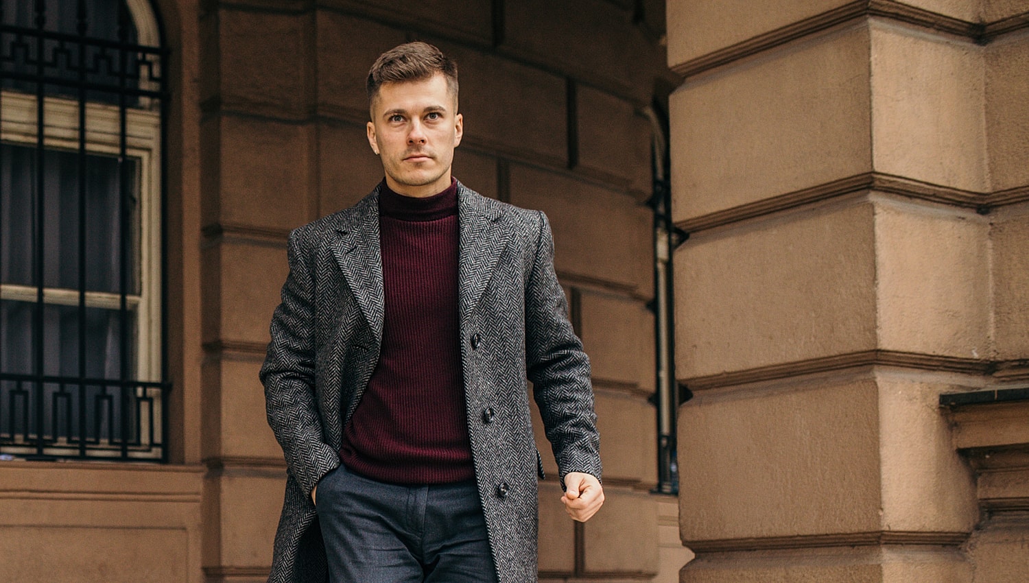 Man in stylish coat walking outside.