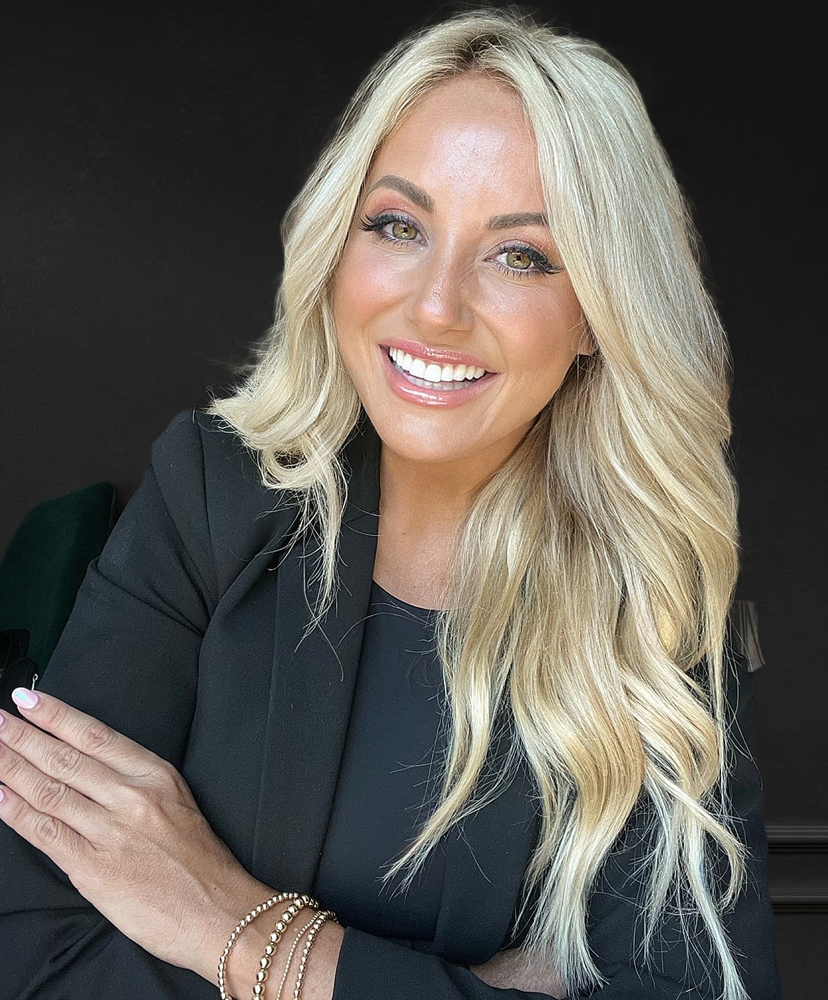 Smiling woman with blonde hair and black blazer.