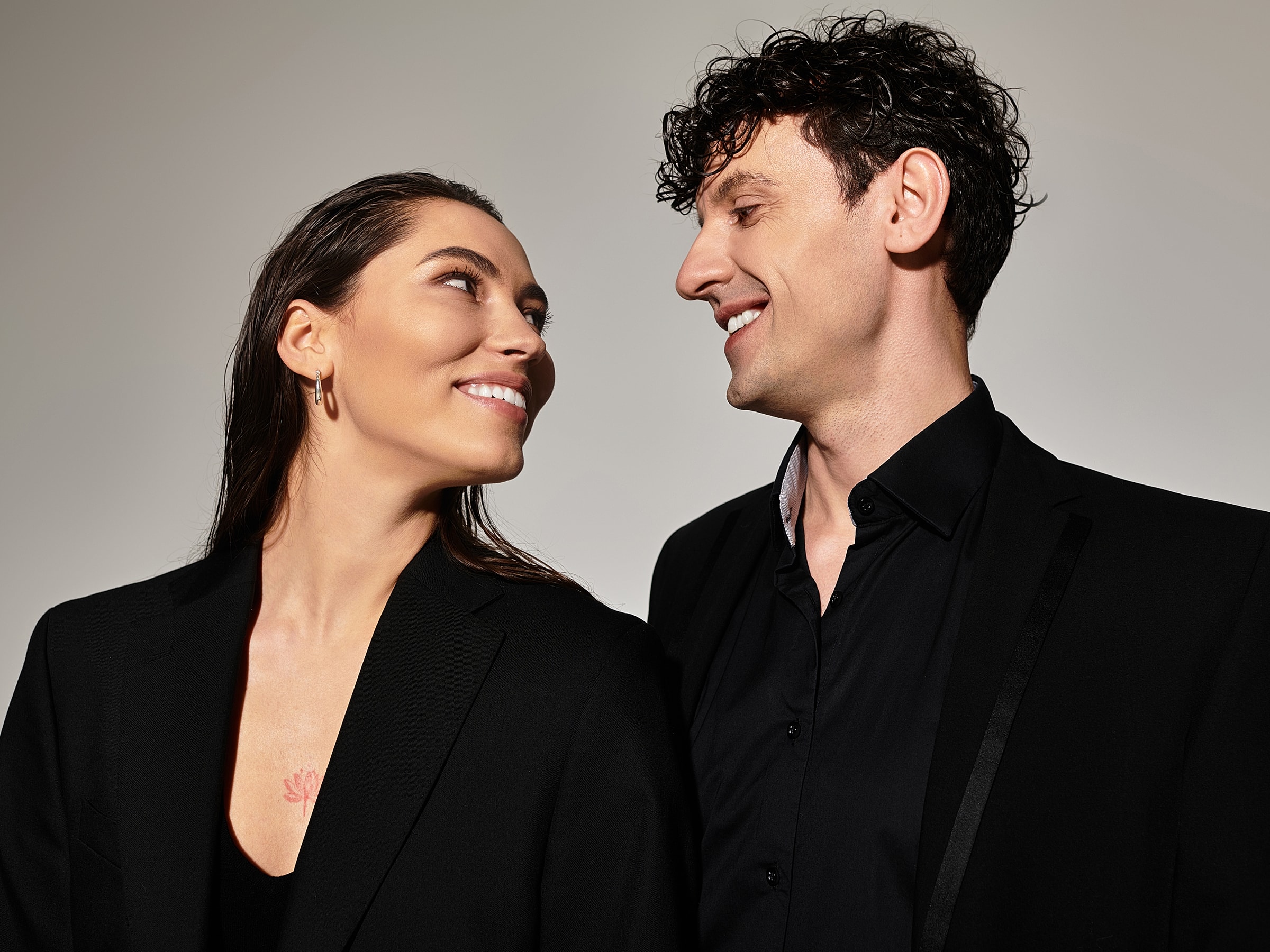 Couple smiling together, wearing black outfits.