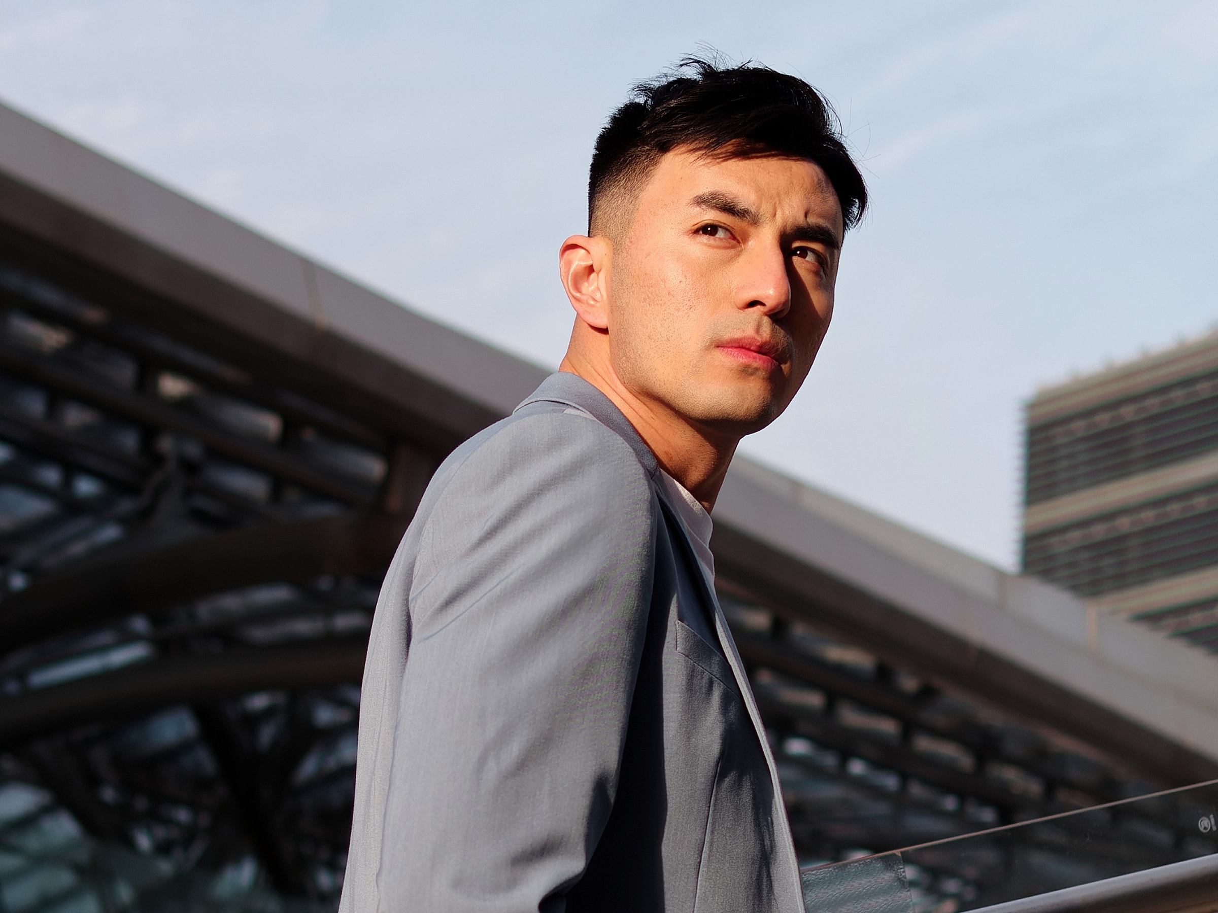 Man in stylish blazer outdoors, looking confidently.