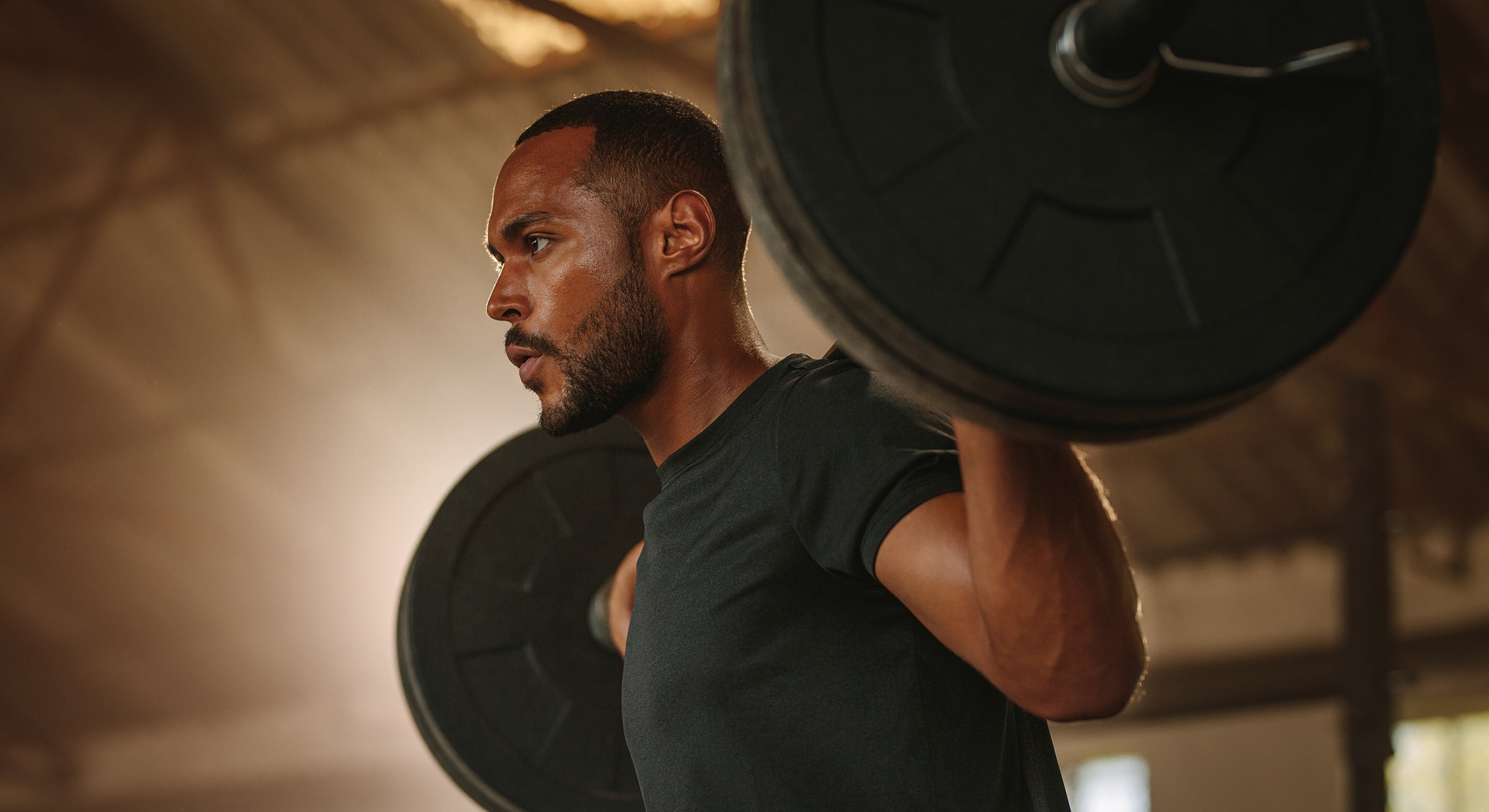 Man lifting weights in a gym setting.